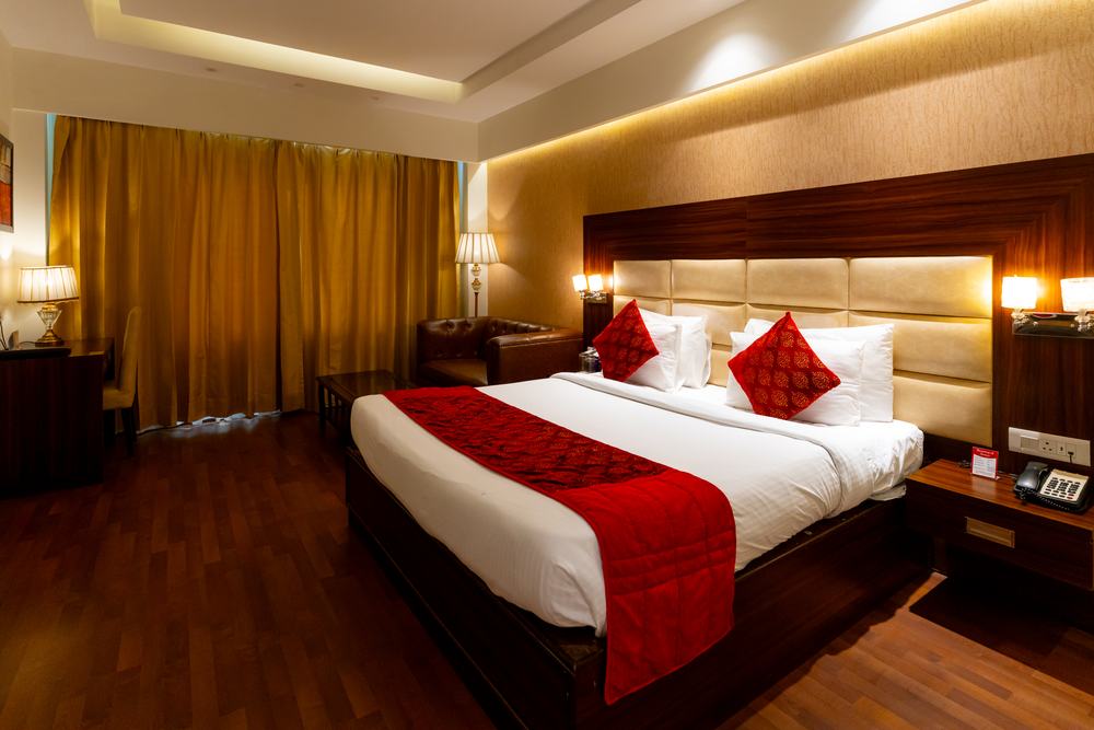 An Executive Room, the bed made up under the padded headboard