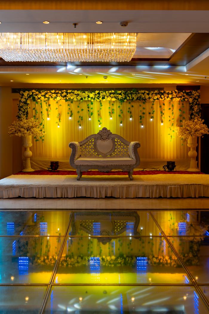 A wedding stage dressed in flowers above the lit floor