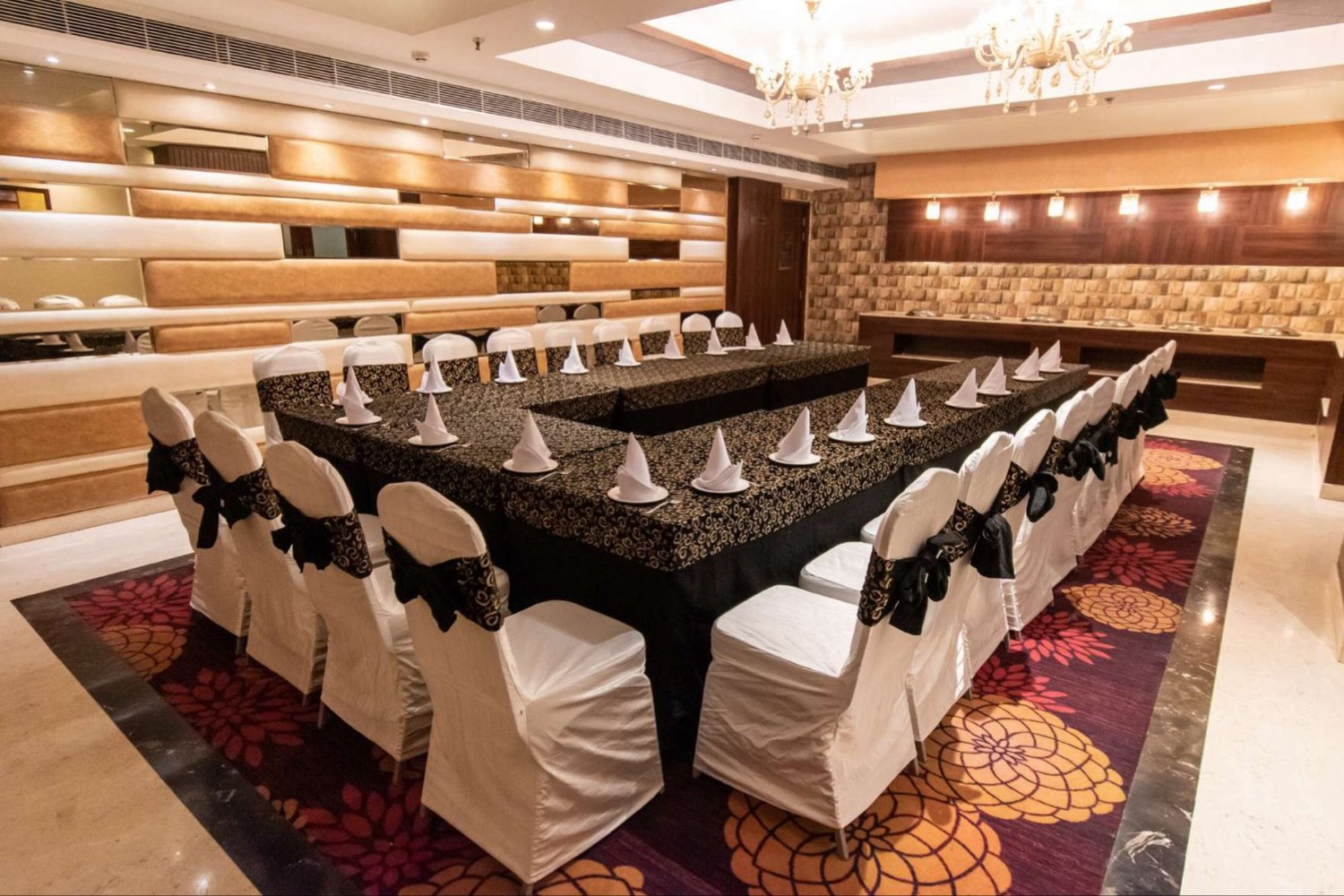 Sparkle, the tables laid in a U in black and gold, white covers on the chairs