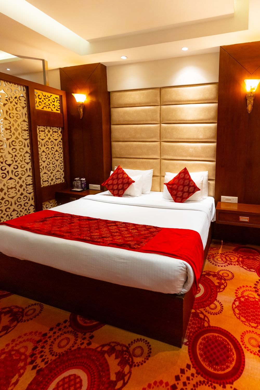 Suite: The bedroom, patterned carpet and quilted headboard