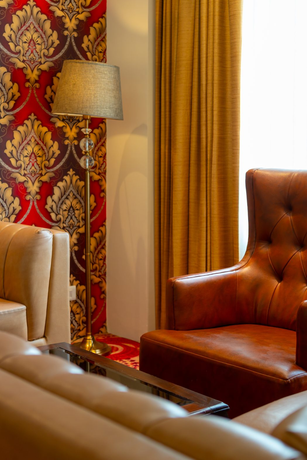A corner of the Suite: damask paper, a floor lamp and a leather armchair
