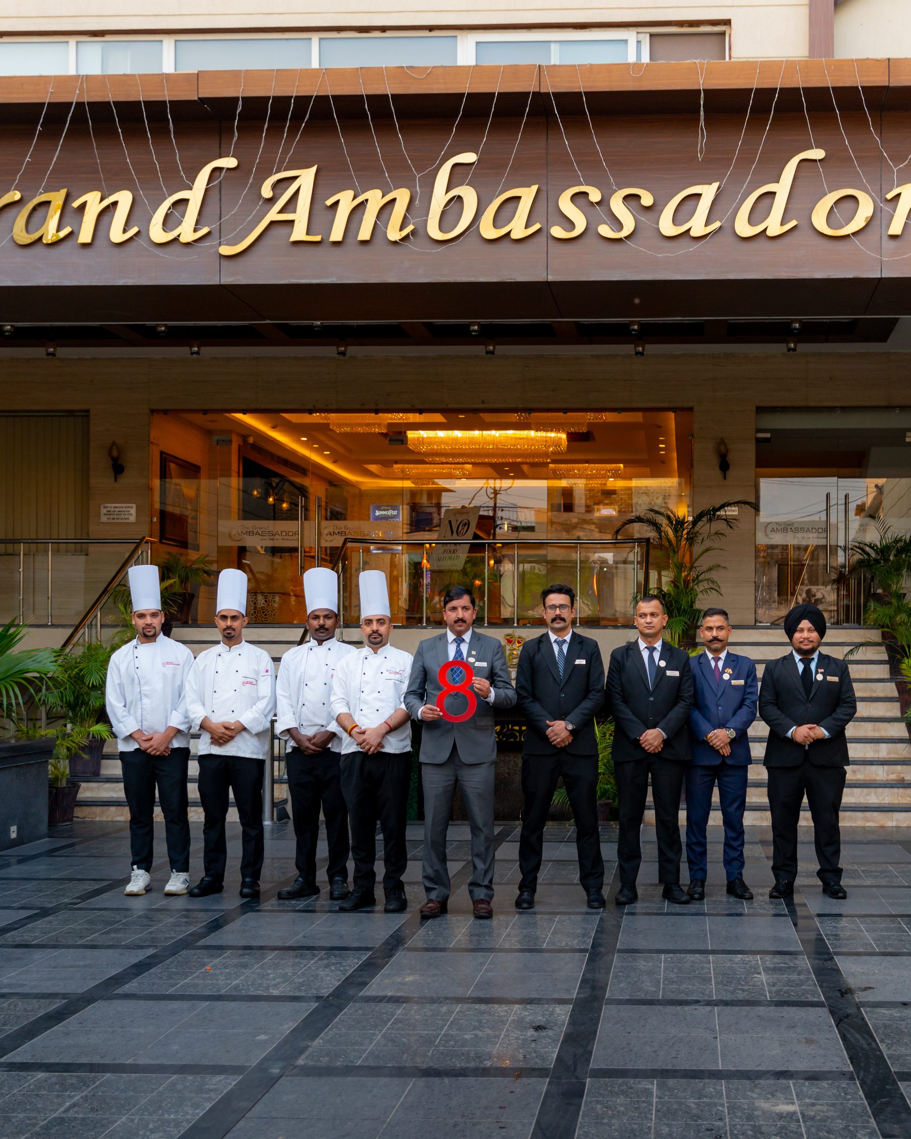 The team on the forecourt, below the hotel's signage