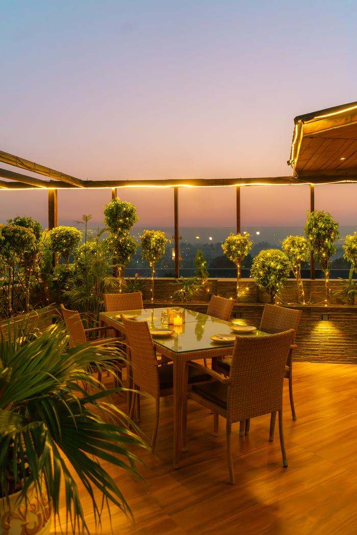 The terrace at dusk, tables among the planters